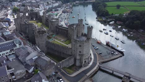 ancient caernarfon castle welsh harbour town aerial view medieval waterfront landmark rising birdseye shot