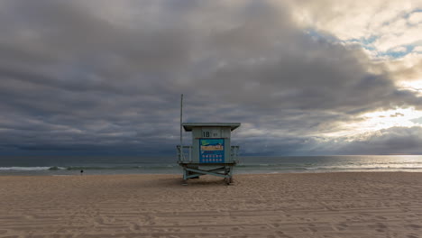 Torre-De-Salvavidas-De-La-Calle-18-Y-Gente-En-La-Playa-De-Manhattan-En-Una-Puesta-De-Sol-En-California,-Estados-Unidos