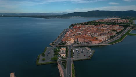 Autos-Auf-Brückenstraße-In-Richtung-Lagune-In-Richtung-Der-Alten-Inselstadt-Orbetello-In-Der-Nähe-Des-Monte-Argentario-Und-Des-Naturparks-Maremma-In-Der-Toskana,-Italien,-Mit-Wasserspiegelungen