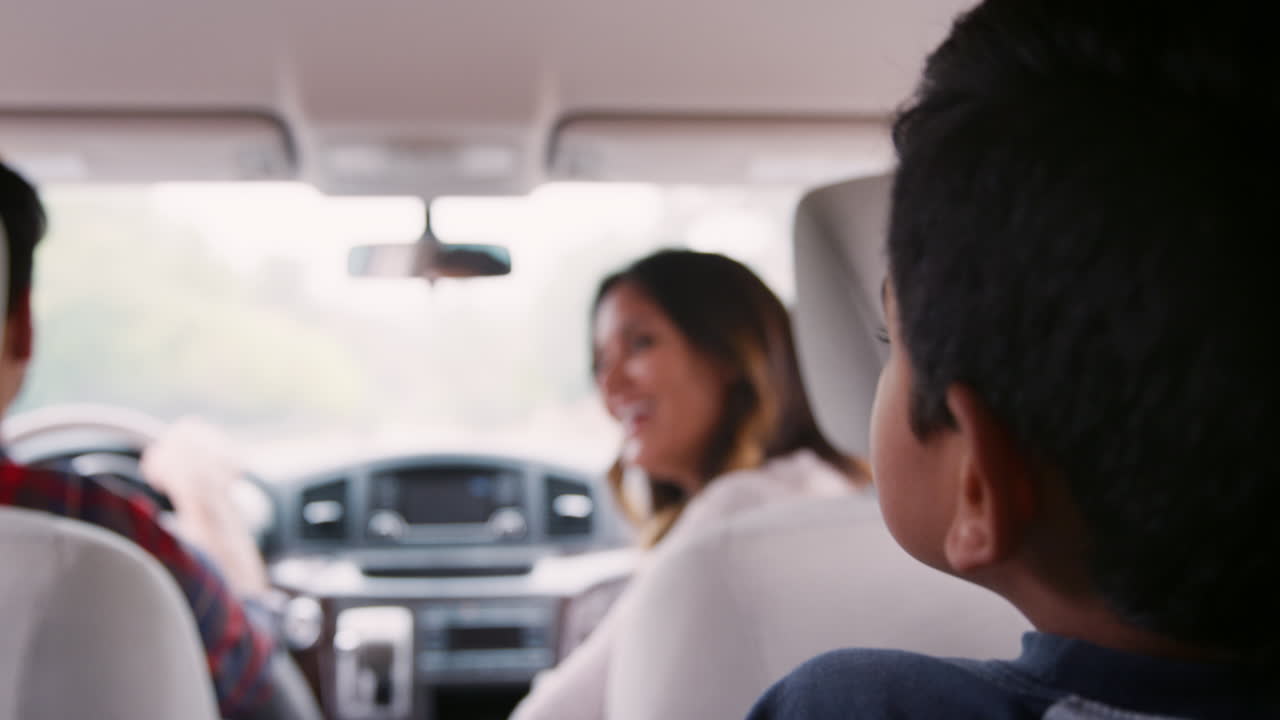niño viajando en la parte trasera de un coche con sus padres