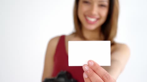 photographer showing visiting card while taking photo with digital camera