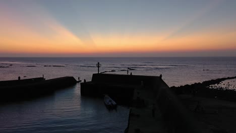 Drone-overtake-shot-of-a-small-harbor-in-China-after-sunset-with-gorgeous-sky-colors