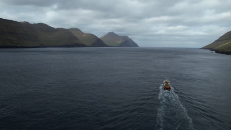 vista aérea en un barco de pesca en un fiordo y que se está alejando