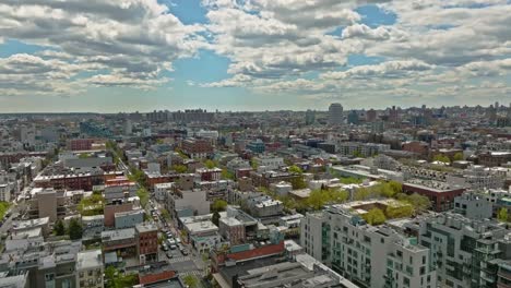 aerial flyover american neighborhood in new york during sunny day with clouds at blue sky - establishing drone shot