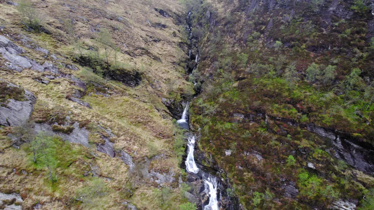 Aerial View of a Stunning Waterfall cascading down a rocky mountainside in Scotland