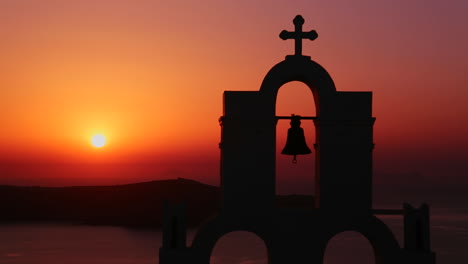 an amazing and beautiful sunset behind a greek orthodox church on the greek island of santorini 4