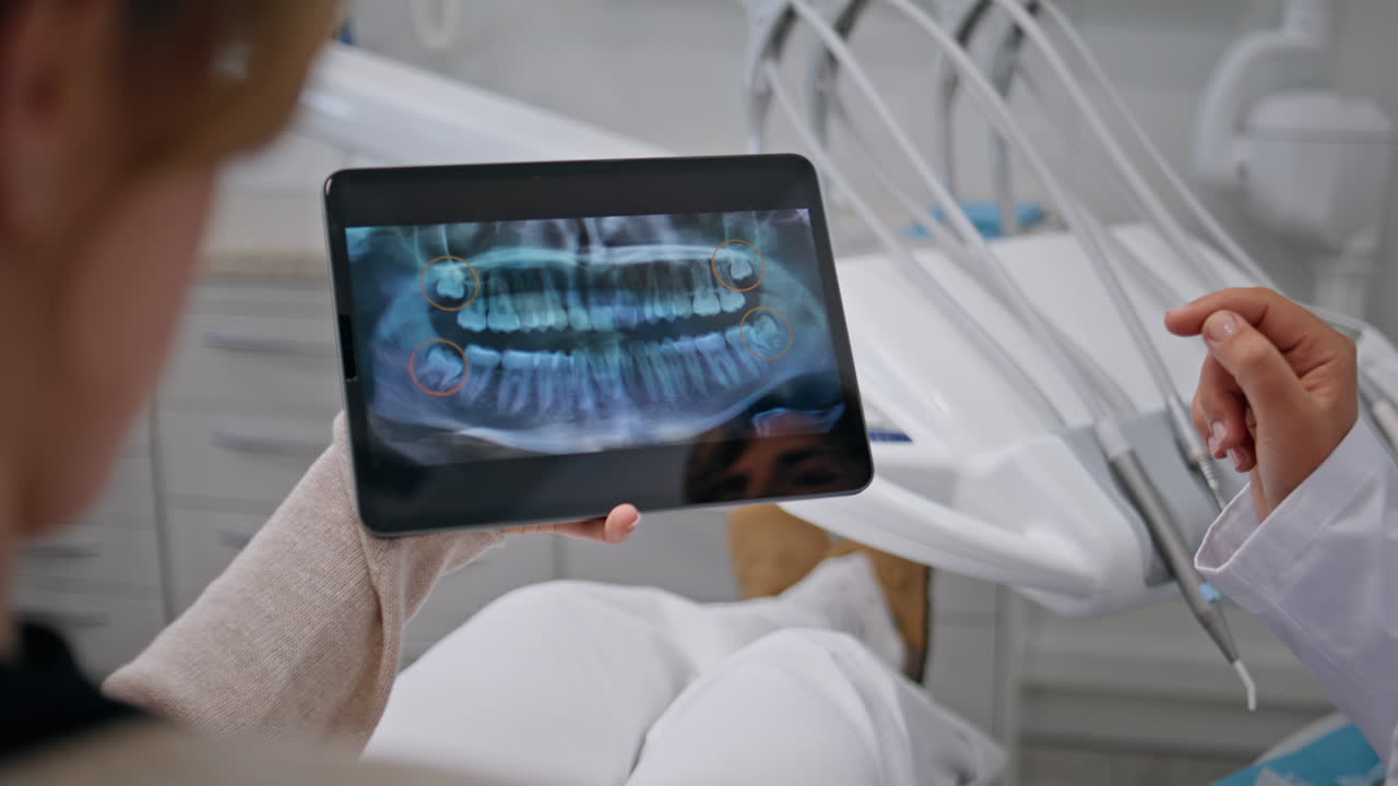 Dentist showing digital x-ray results to patient at clinic visit closeup