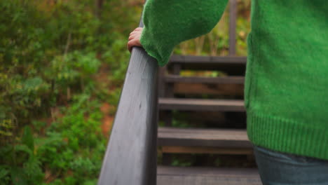 woman walking up wooden stairs in a forest