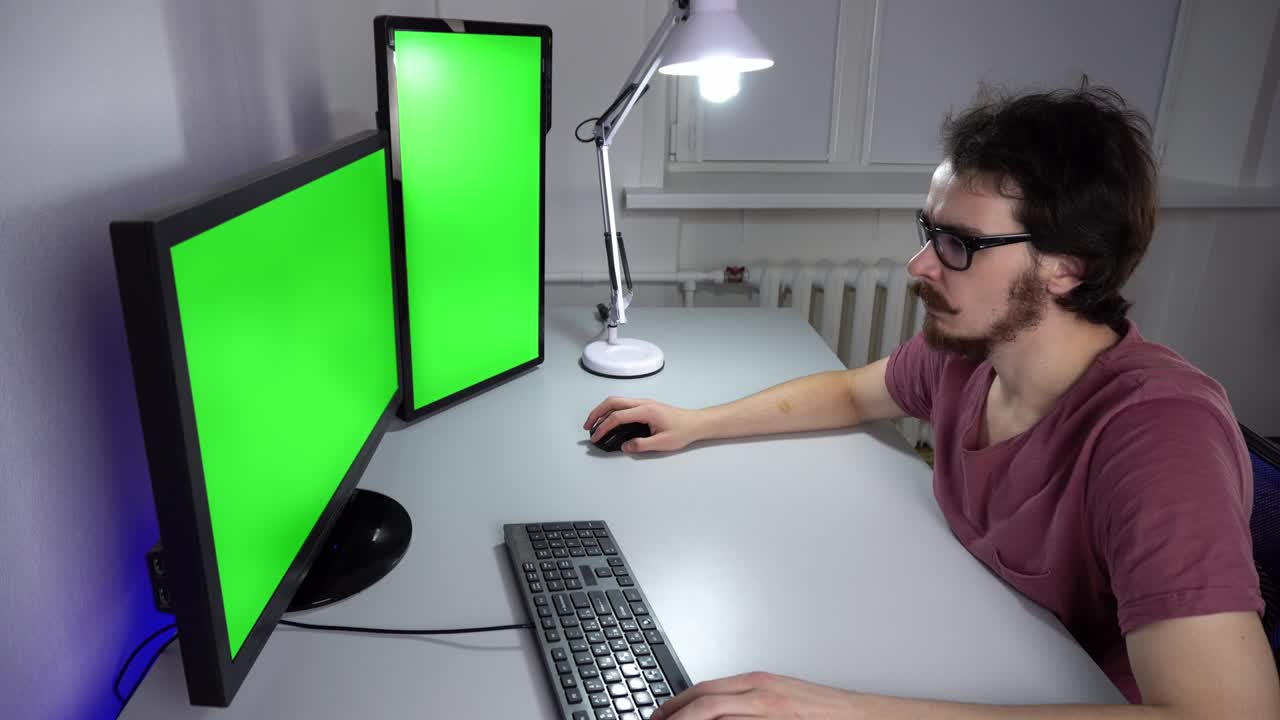programador concentrado está trabajando en la computadora con llave chroma en dos monitores
