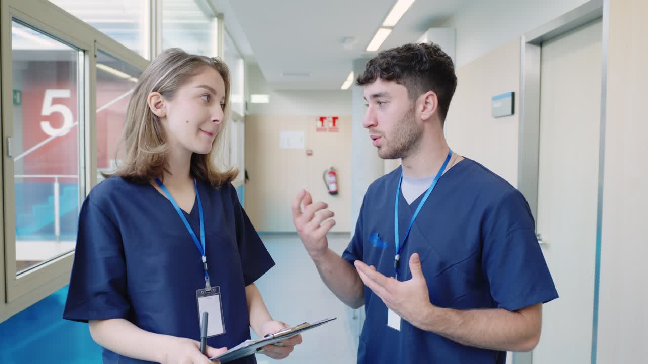 Nurses discussing patient care in hospital corridor