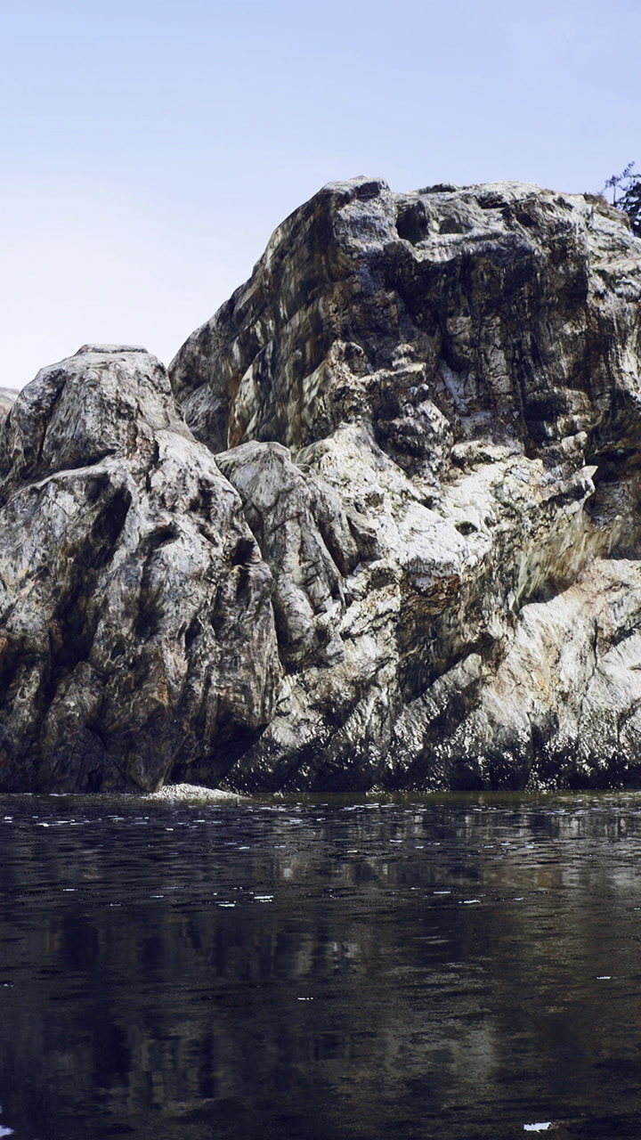 Rocks by the water under a blue sky during the day