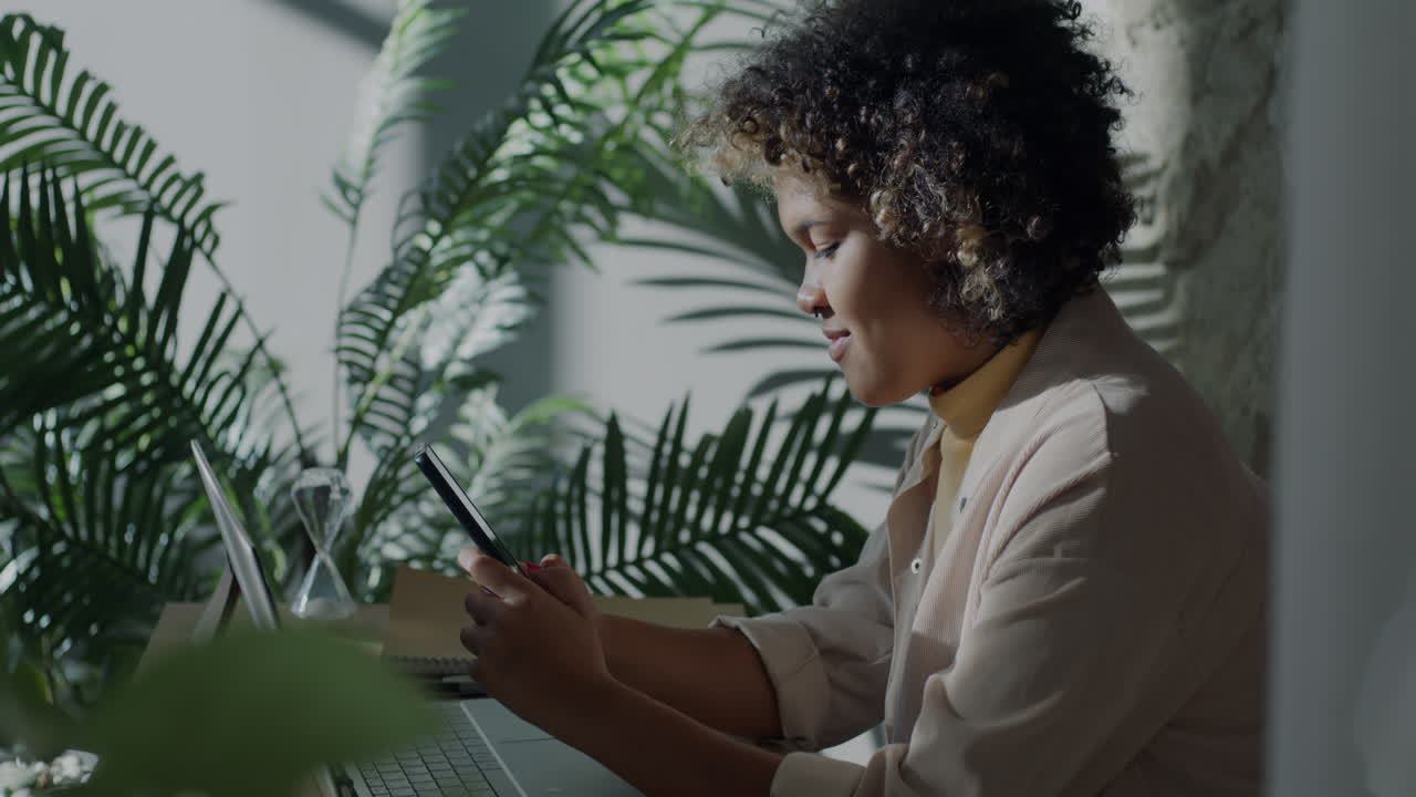 Donna che lavora al laptop e al telefono in un ufficio domestico
