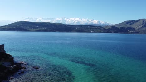 un retroceso revela imágenes aéreas de drones de 4k de las montañas blancas lefka ori de creta, sobre pequeñas islas de la bahía de souda