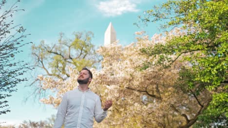 músico cantando y interpretando una canción con el monumento a washington en el fondo