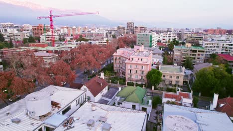 Aerial-view-dolly-in-residential-neighborhood-of-Providencia-pink-neoclassical-Parisian-style-building-in-Santiago,-Chile