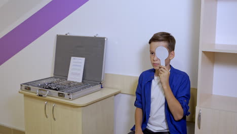 portrait of handsome boy checking eyesight. professional ophthalmologist checks the eyesight of the child. eye examination.