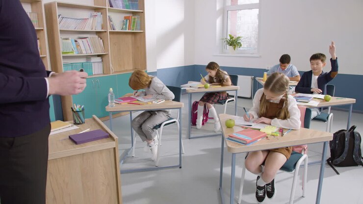 Gruppo di alunni multietnici che scrivono sul quaderno, poi un ragazzo si alza e va alla lavagna