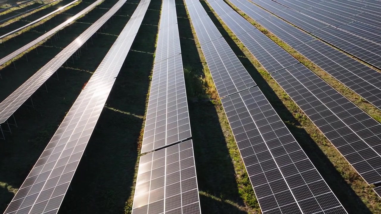 Luftfoto viser rækker af solpaneler i et landligt landskab, der producerer ren elektricitet gennem