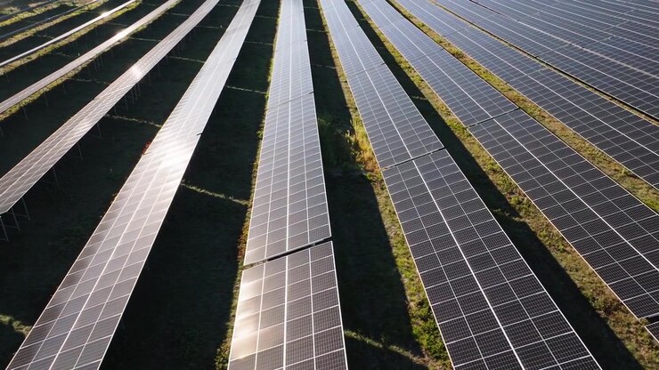 Luftfoto viser rækker af solpaneler i et landligt landskab, der producerer ren elektricitet gennem