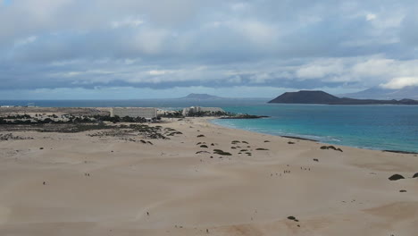 Luftaufnahme-Des-Strandes-Von-Fuerteventura,-Der-Sich-über-Den-Hotelresorts-An-Der-Sonnigen-Küste-Und-Den-Lobos-Inseln-Erhebt