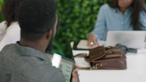 young-african-american-engineers-developing-mobile-software-application-using-digital-tablet-computer-brainstorming-design-solution-sharing-ideas-collaborating-in-startup-office-meeting-close-up