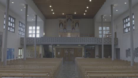View into the empty church room of the Bruder Klaus church in Gundelfingen, Germany, a man is playing the organ