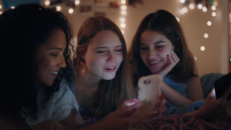 Adolescentes-Felices-Acostadas-En-La-Cama-Usando-Teléfonos-Inteligentes-Navegando-Por-Las-Redes-Sociales-Enviando-Mensajes-De-Texto-Compartiendo-Chismes-Disfrutando-De-Dormir-El-Fin-De-Semana