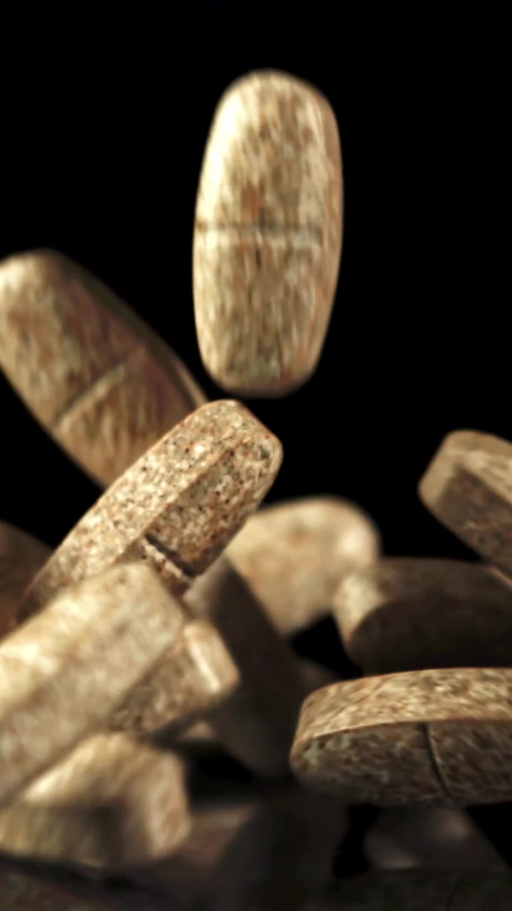 Slow Motion Close-Up of Brown Pills Falling on Black Background
