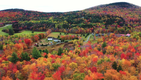 Aerial-View-of-Fairy-Tale-Landscape-Multicolored-Forest-Autumn-Foliage-and-Ranch-Houses-in-American-Countryside,-Drone-Shot