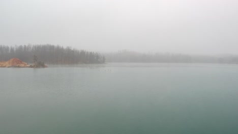 Cuatro-Patos-Despegando-De-Un-Lago-Y-Volando-Con-La-Cámara-Siguiéndolos