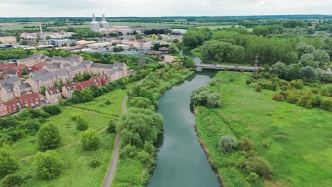 fotografía aérea de un puente sobre un canal con casas y apartamentos de lujo y rodeado de vegetación en inglaterra