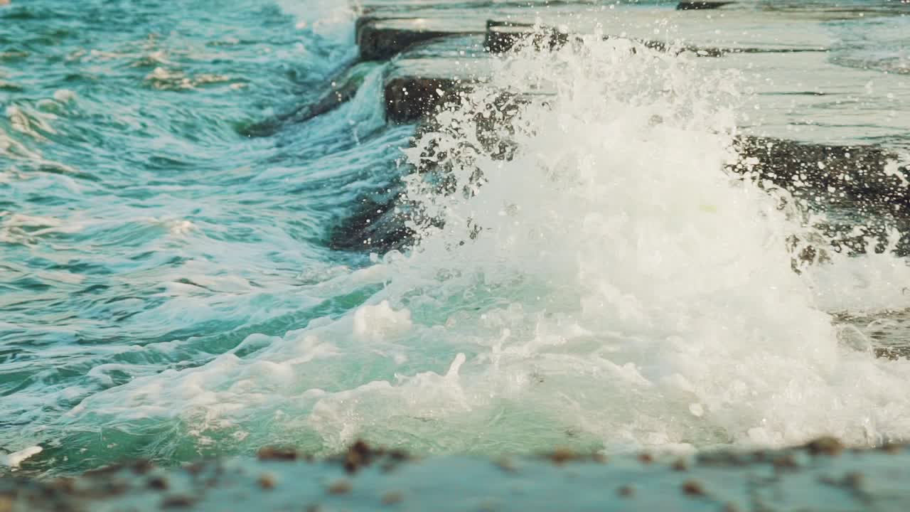 sea waves are crashing with foam on the rocks of the coast in the summer. Slow motion