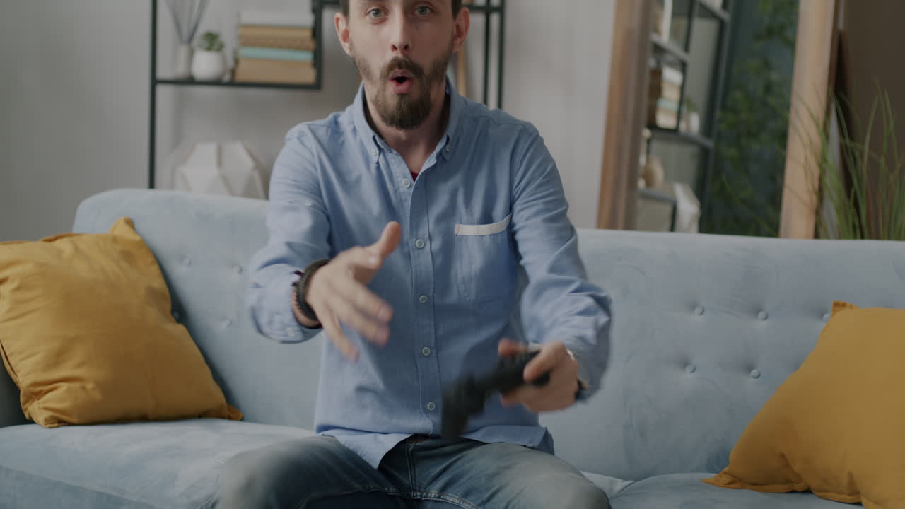 Uomo che gioca ai videogiochi su un divano