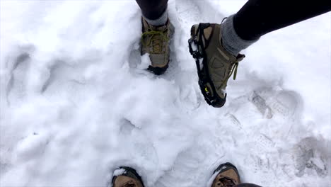 man and woman wearing snow cleats during a snowstorm