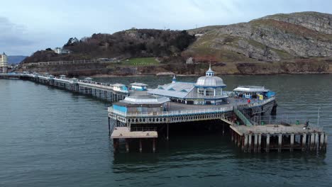 llandudno pier welsh victorian boardwalk resort promenade aerial view slow low right orbit shot