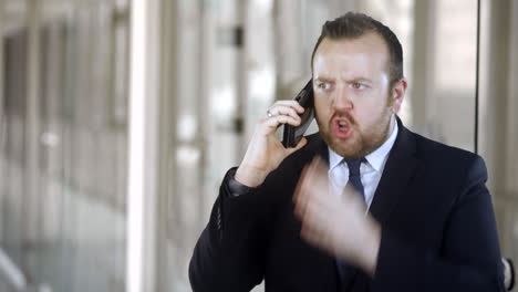 an angry businessman is talking on the phone