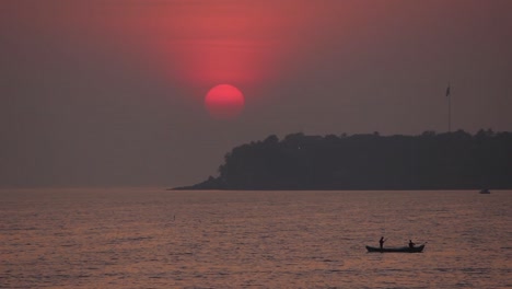 beautiful view of sunset from mumbai marine drive with a small fisherman boat and a island silhouette stock video i sunset view stock video in full hd