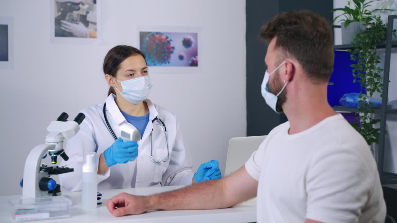 el médico comprueba la temperatura del paciente