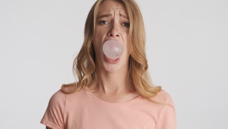 caucasian woman blowing bubblegum on camera.