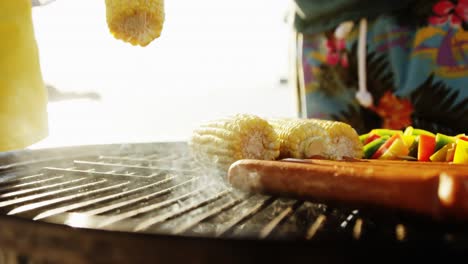 preparing corn and hotdog on barbecue at the beach 4k