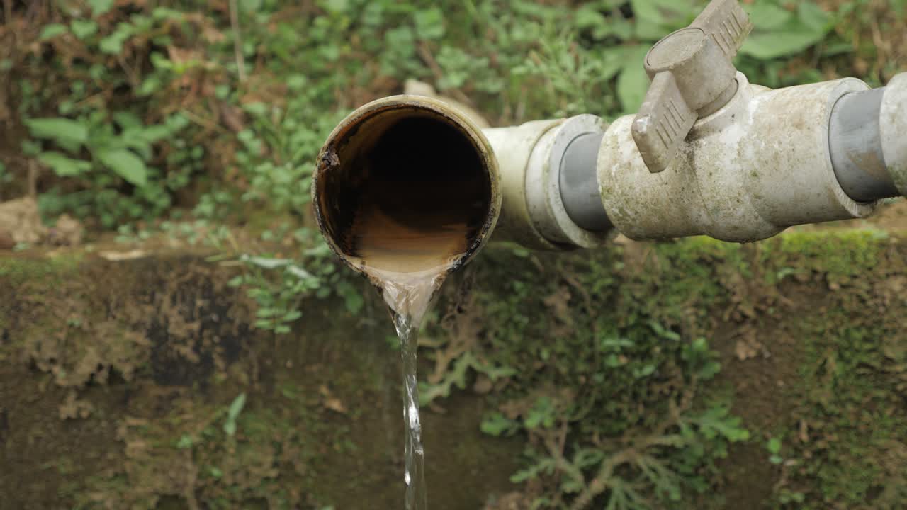 Shot of a large water drain container with waste water flowing out the pipe on plantation factory Sierra Nevada Colombia slowmotion