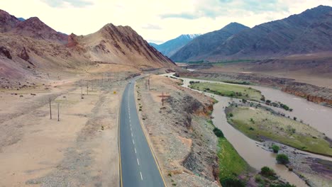 Aerial-drone-shot-of-a-road-through-Himalayan-Mountains-landscape-in-barren-cold-desert-of-Ladakh-India