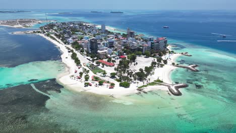 Tropical island town with white sandy beaches and clear turquoise water from above. Maafushi, Maldives.