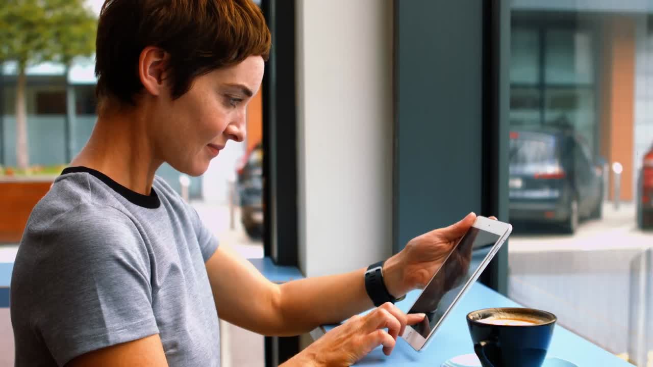 mujer de negocios usando una tableta digital mientras toma café
