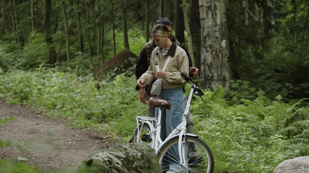 Couple with a bicycle in a forest