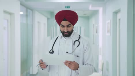 happy sikh indian doctor checking medical reports