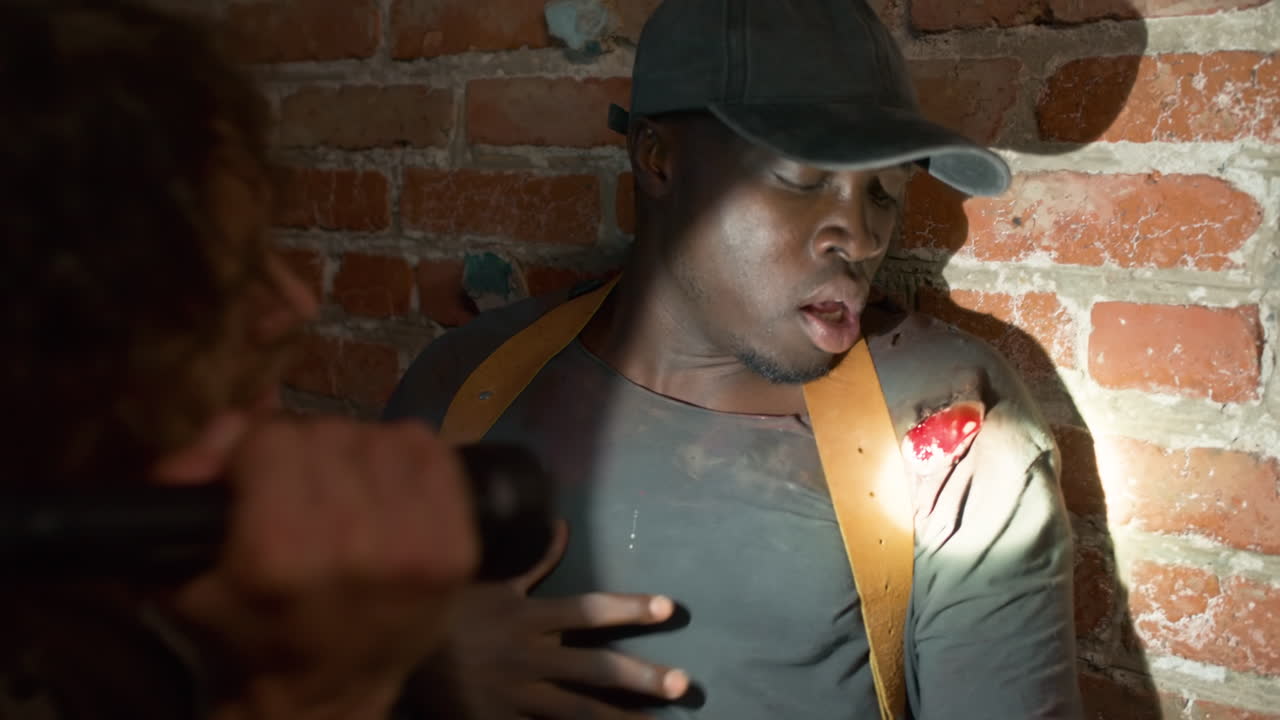 человек, помогающий раненому другу.