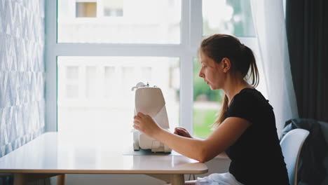 una mujer de cabello largo y oscuro se sienta en una mesa blanca