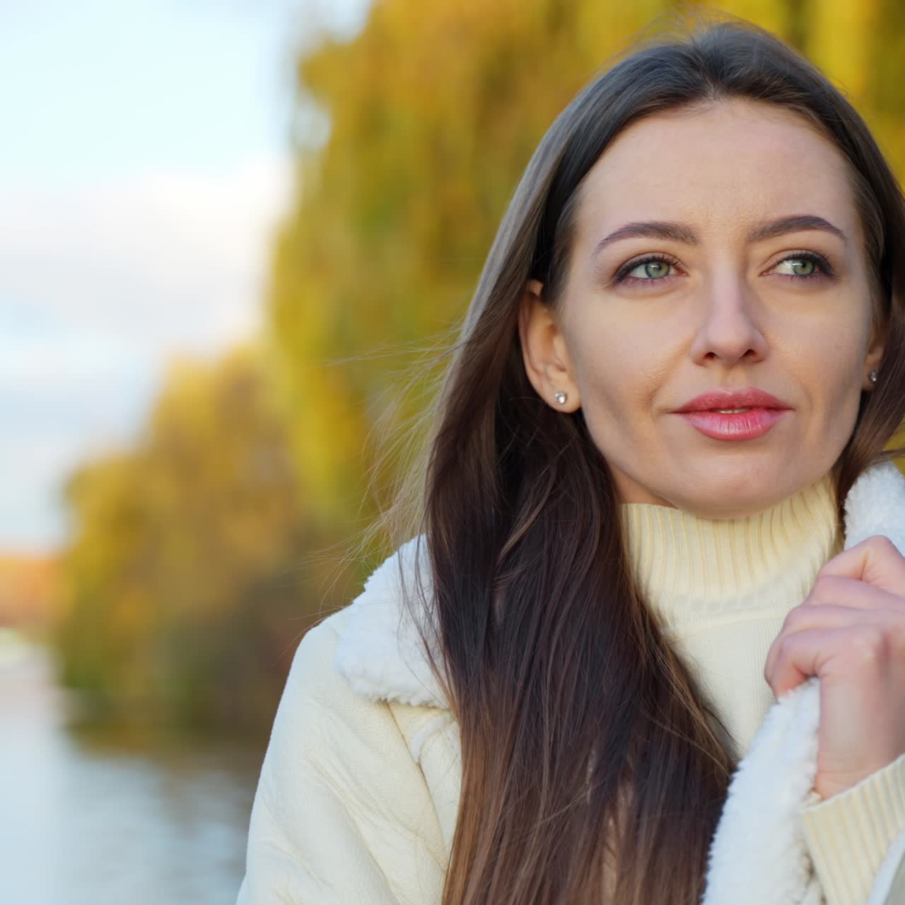 Attractive cheerful woman wearing coat. Portrait of young lady in autumn background