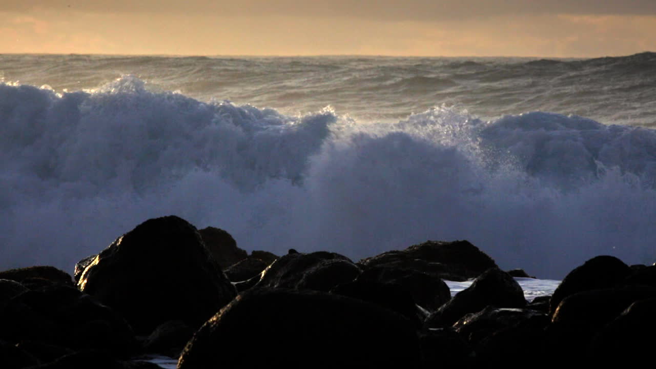 olas azotadas por el viento ruedan en una playa después de una gran tormenta 1